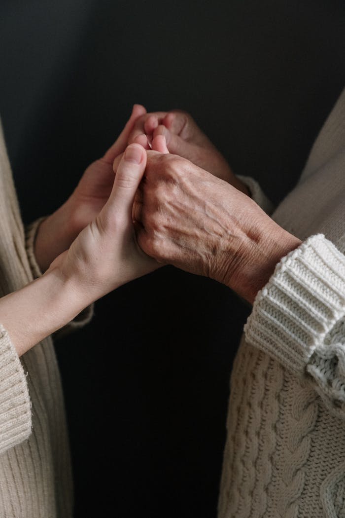 Two generations connect through holding hands, symbolizing love and unity.