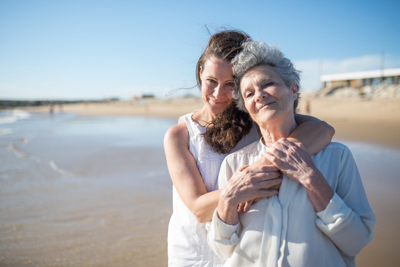 Heartwarming photo of mother and daughter embracing on a sunny Portuguese beach.